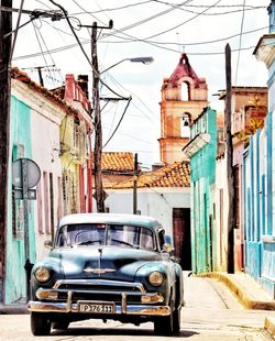 Car on street against buildings in city