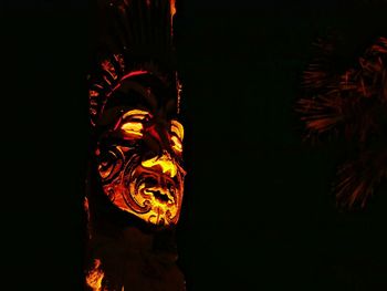 Low angle view of illuminated statue against black background
