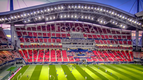 Crowd on soccer field against sky at night