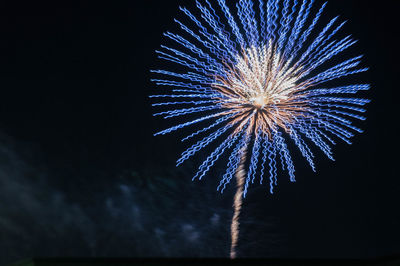Low angle view of firework display at night