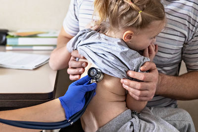 Little girl  in the doctor's office.the doctor listens to the lungs with a phonendoscope.