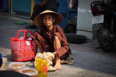 Full length of man sitting in basket on street