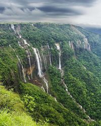 Scenic view of waterfall against sky