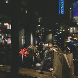 People standing on illuminated street at night