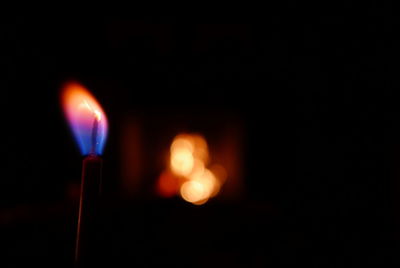 Close-up of lit candle in dark room