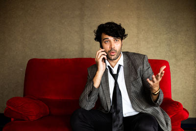 Portrait of young man sitting on sofa