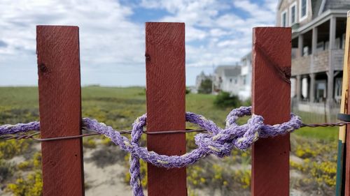 Close-up of rope on wooden post against building