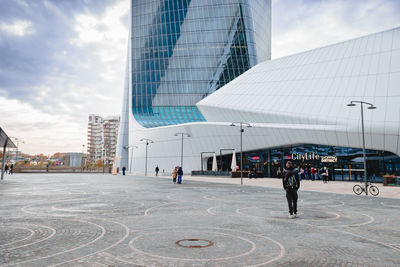 People walking on street against buildings