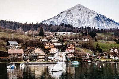 Scenic view of lake by buildings against sky