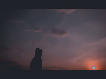 Silhouette woman standing against sky during sunset