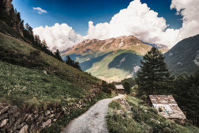 Road by mountains against sky