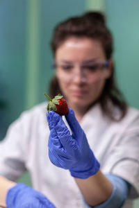 Portrait of young woman holding strawberries