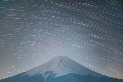 Scenic view of snowcapped mountains against sky at night