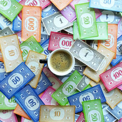 Directly above shot of coffee cup on paper currencies