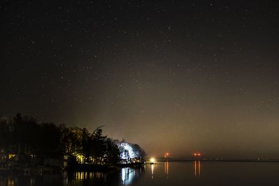 Scenic view of lake against sky at night