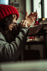 Side view of woman pinting at home