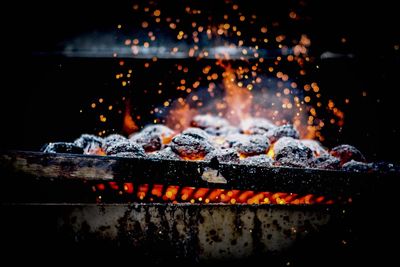 Close-up of burning coal on metal grill