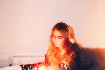 Girl with illuminated lights sitting at home