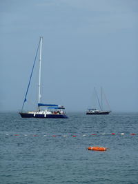 Sailboat sailing on sea against sky