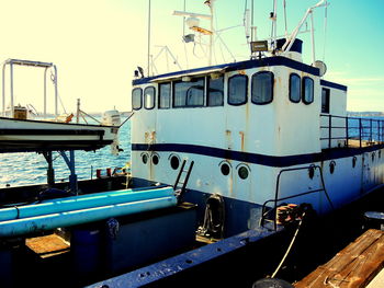 Boats moored at harbor against sky