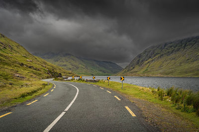 Winding road leading trough doloough valley with lake, glencullin, ireland