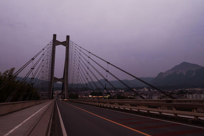 View of suspension bridge in city against clear sky