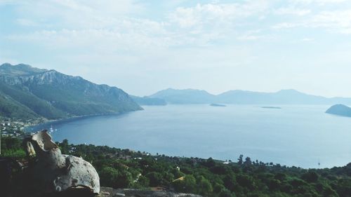 Scenic view of sea and mountains against sky