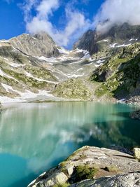 Scenic view of lake by mountains against sky