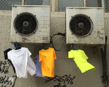 T-shirts on hanger hanging against air duct 