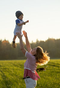 Full length of mother and daughter on field against sky