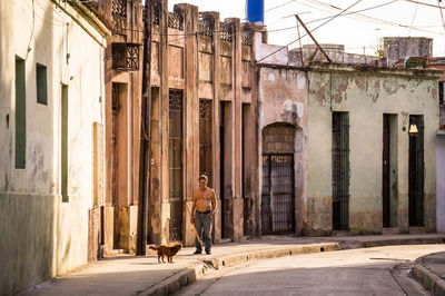 Man walking on street amidst buildings in city