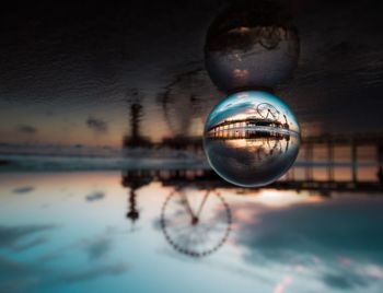 Close-up of crystal ball against calm lake