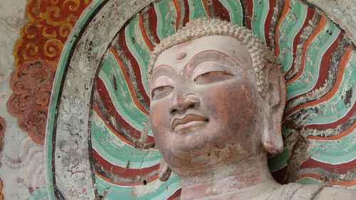 Close-up of buddha statue against building