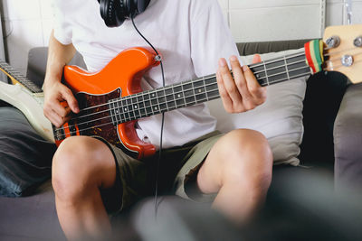 Midsection of man playing guitar