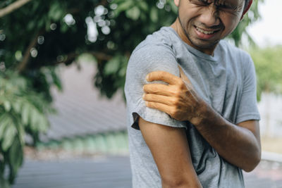 Midsection of man holding ice cream standing outdoors