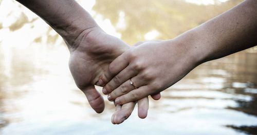 Midsection of couple holding hands