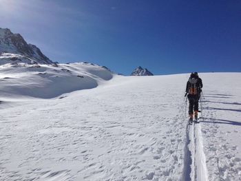 Man climbing on snow covered mountain