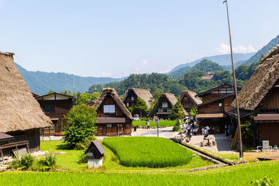 Scenic view of houses and mountains against sky