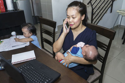 Mother and daughter sitting on laptop