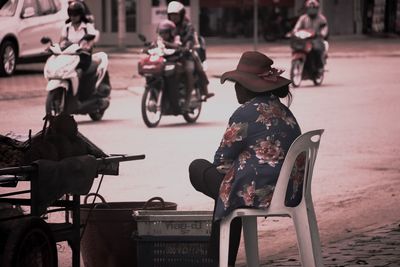 People riding motor scooter on street in city