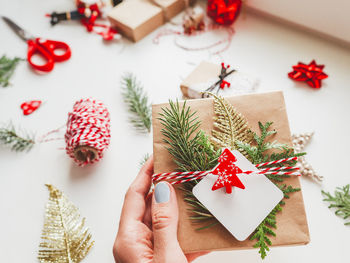 New year presents in craft paper with fir tree twigs and red symbol of christmas tree. winter holida