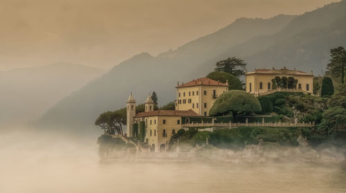 Building by mountains against sky