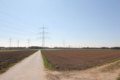 Road amidst field against sky