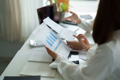 Midsection of businessman working on table