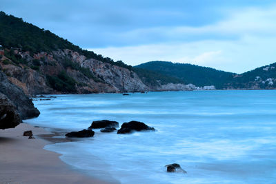 Scenic view of sea and mountains against sky