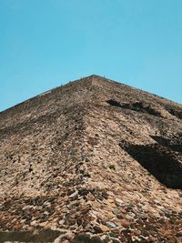 Low angle view of stone wall against blue sky