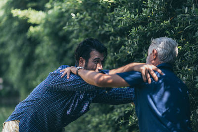 Man and woman standing by tree