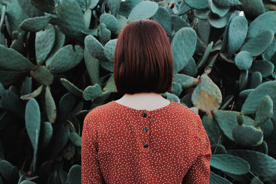 Rear view of woman standing by plants