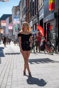 Portrait of young woman walking on street in city