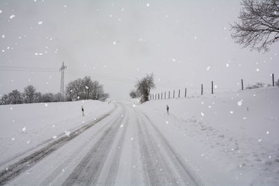 Snow covered road against sky during winter